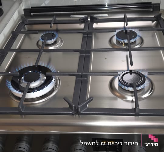 כיריים גז מנירוסטה עם להבות דולקות וכלי עבודה של טכנאי גז